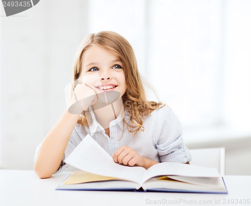 Image of little student girl studying at school