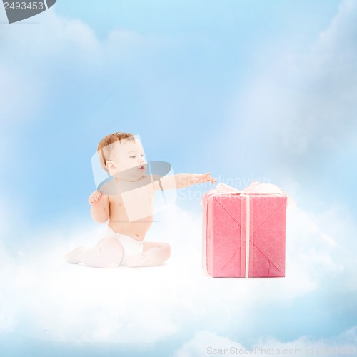 Image of smiling baby with present on the cloud