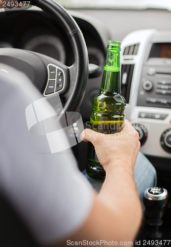 Image of man drinking alcohol while driving the car