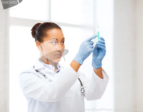 Image of african doctor holding syringe with injection