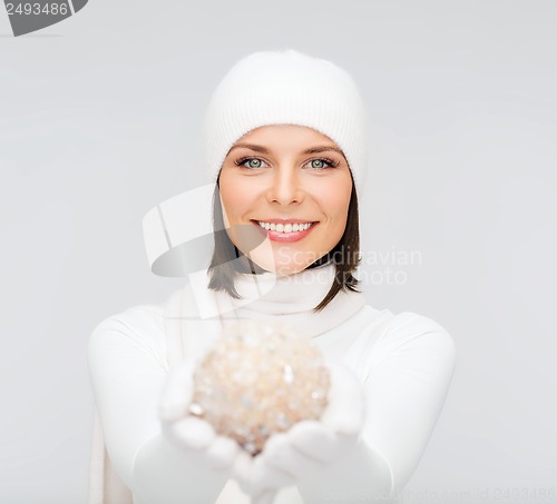 Image of woman in hat and gloves with christmas ball