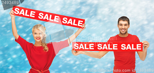 Image of woman and man with red sale signs