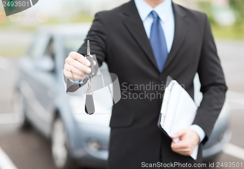 Image of man with car key outside