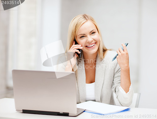 Image of businesswoman with smartphone in office
