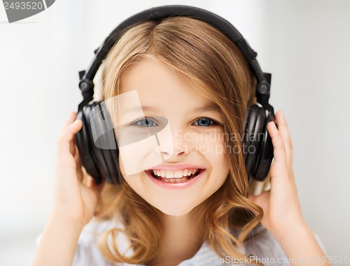 Image of little girl with headphones at home