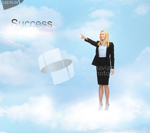 Image of businesswoman pointing at success word in the sky