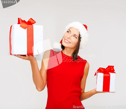 Image of woman in santa helper hat with many gift boxes