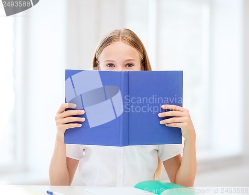 Image of girl studying and reading book at school