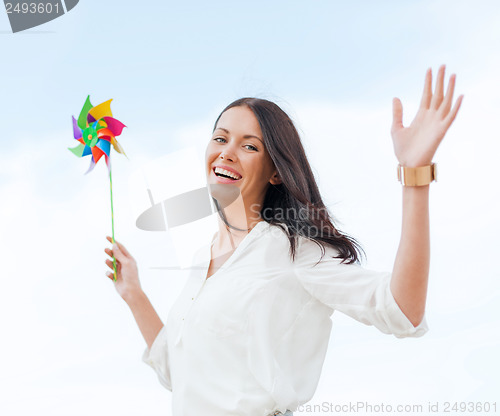 Image of girl with windmill toy on the beach