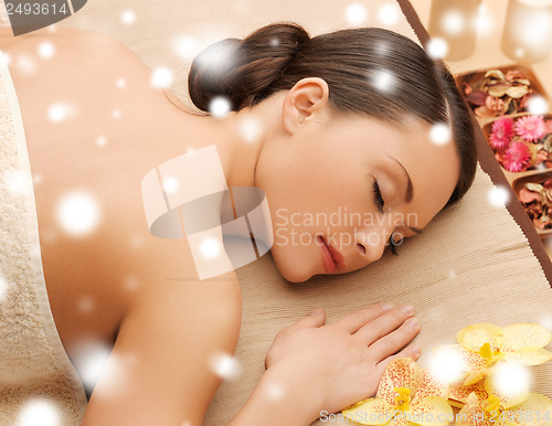 Image of woman in spa salon lying on the massage desk