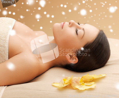 Image of woman in spa salon lying on the massage desk