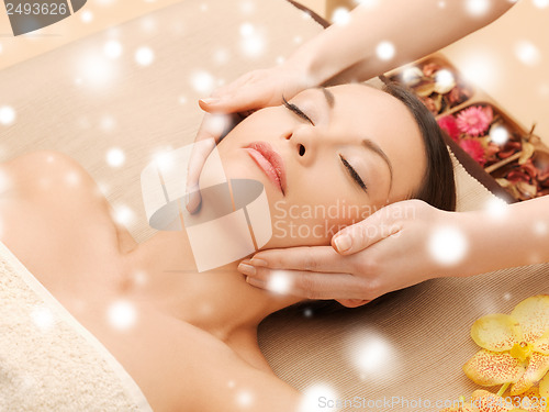 Image of woman in spa salon lying on the massage desk