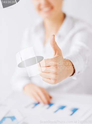 Image of woman with charts, papers and thumbs up