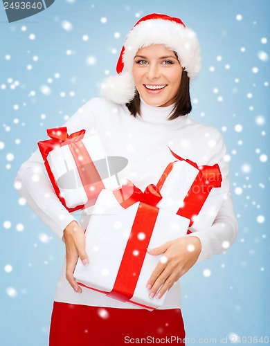 Image of woman in santa helper hat with many gift boxes