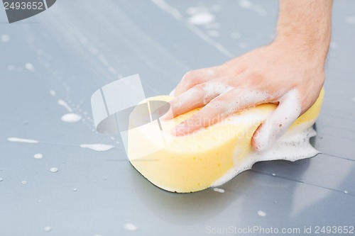 Image of man washing a car