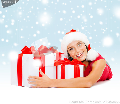 Image of smiling woman in santa helper hat with gift boxes