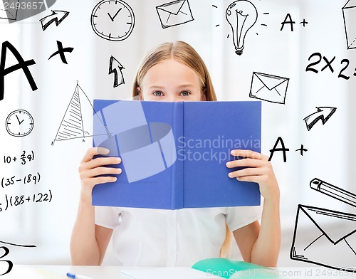 Image of girl studying and reading book at school
