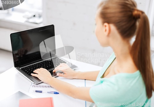 Image of businesswoman with laptop computer in office