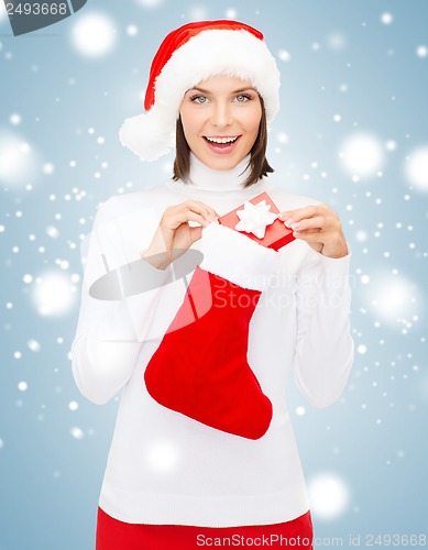 Image of woman in santa hat with gift box and stocking