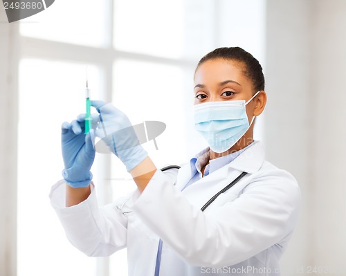 Image of african doctor holding syringe with injection