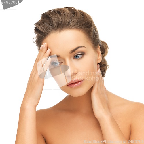 Image of woman holding hands on her neck and forehead