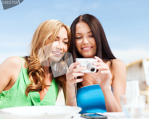 Image of girls with camera in cafe on the beach