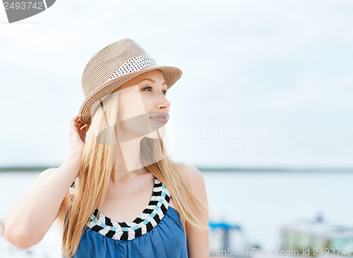Image of girl in hat standing on the beach