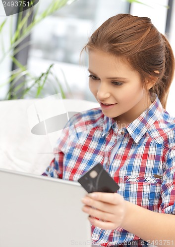Image of happy teenage girl with laptop and credit card