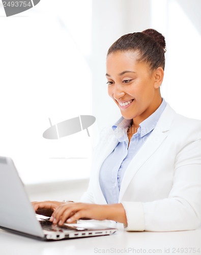 Image of businesswoman with laptop in office