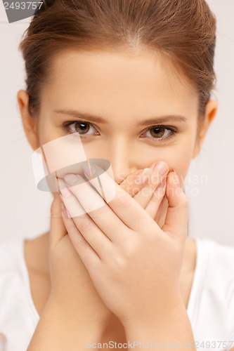 Image of face of beautiful teenage girl covering her mouth