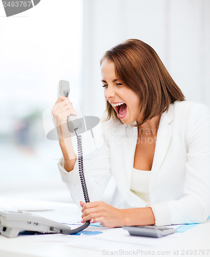 Image of woman shouting into phone in office