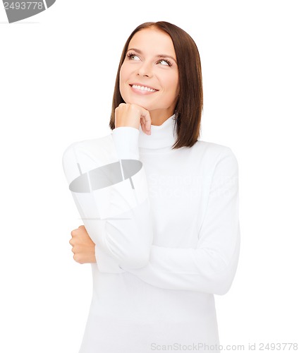 Image of thinking and smiling woman in white sweater