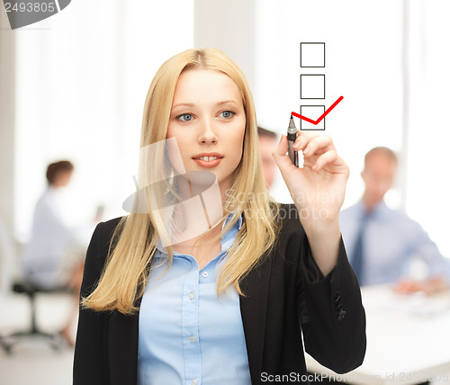 Image of businesswoman drawing checkmark on virtual screen