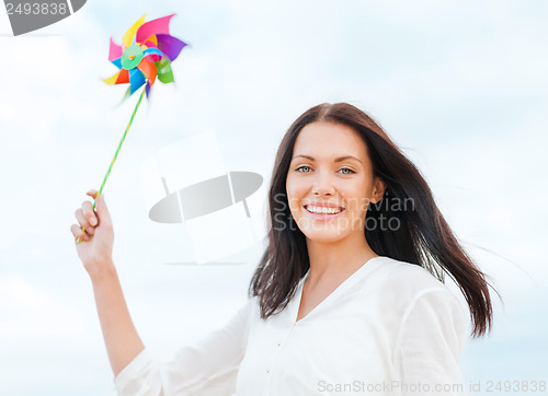 Image of girl with windmill toy on the beach