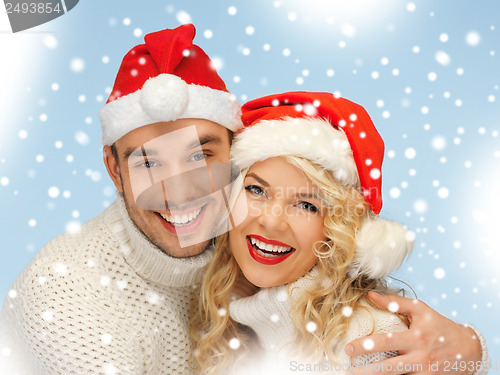 Image of family couple in sweaters and santa's hats