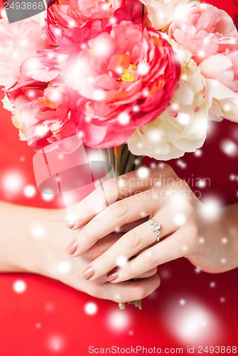 Image of woman hands with flowers and ring