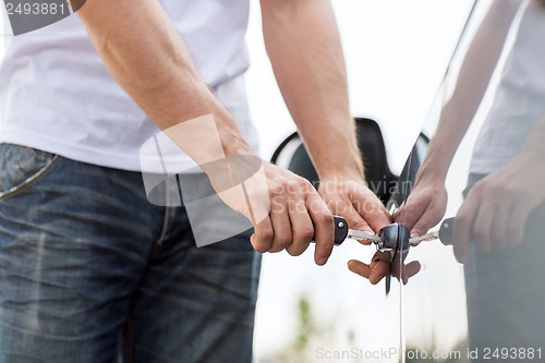 Image of man with car key outside