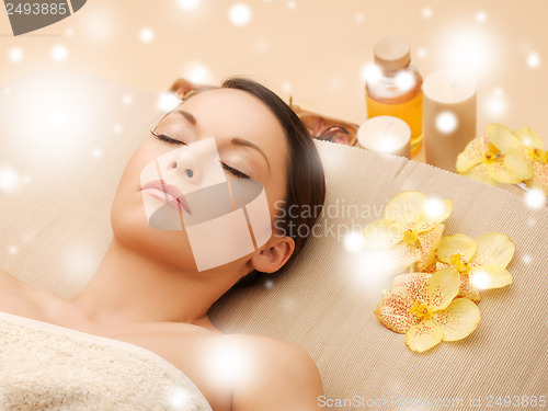 Image of woman in spa salon lying on the massage desk