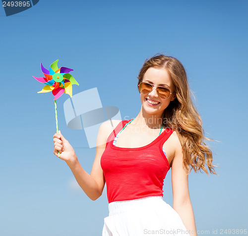 Image of girl with windmill toy on the beach