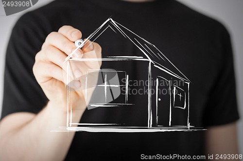 Image of man drawing a house on virtual screen