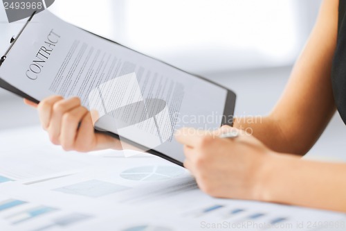 Image of woman hand signing contract paper