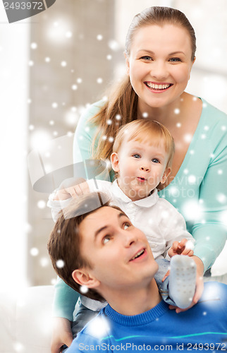 Image of happy parents playing with adorable baby