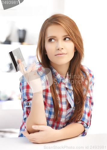 Image of pensive teenage girl with credit card