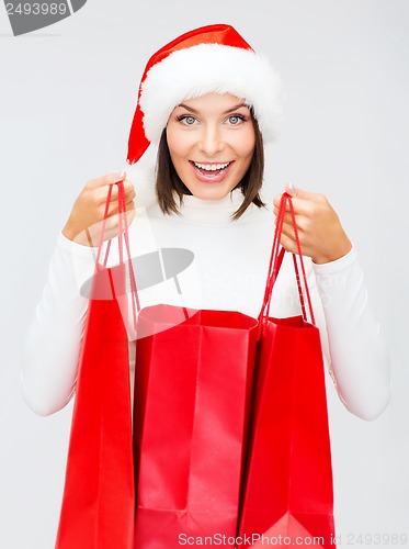 Image of woman in santa helper hat with shopping bags