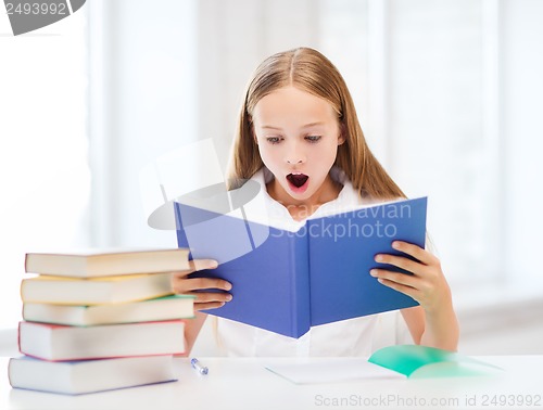 Image of girl studying and reading book at school