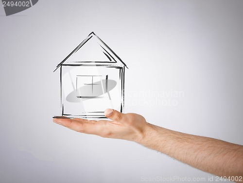 Image of house on virtual screen in man hand