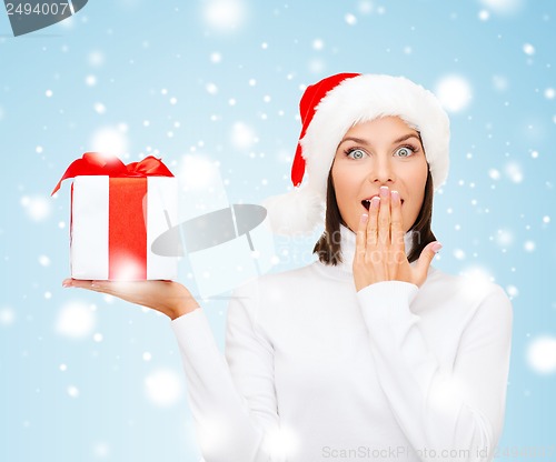 Image of surprised woman in santa helper hat with gift box