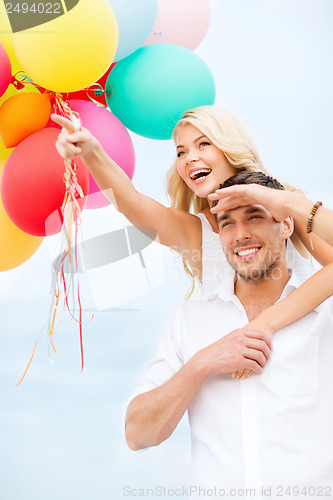 Image of couple with colorful balloons at seaside