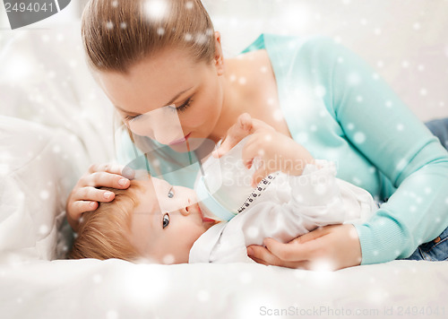 Image of mother and adorable baby with feeding-bottle