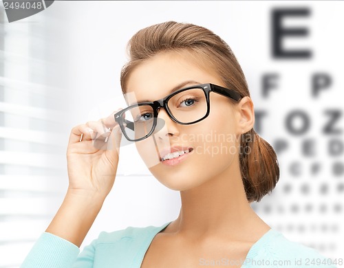 Image of woman in eyeglasses with eye chart